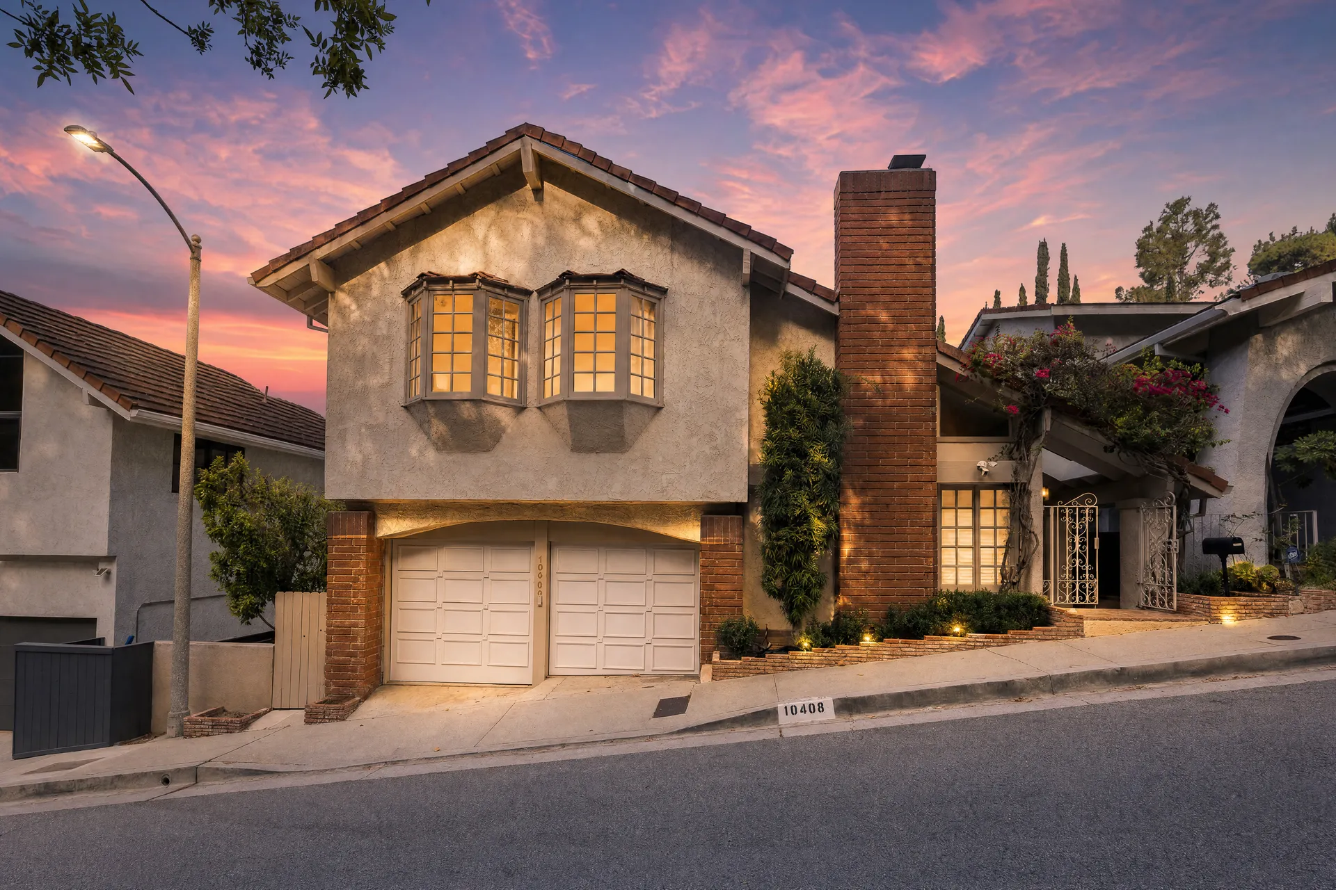 A home's front exterior illuminated against the evening sky.
